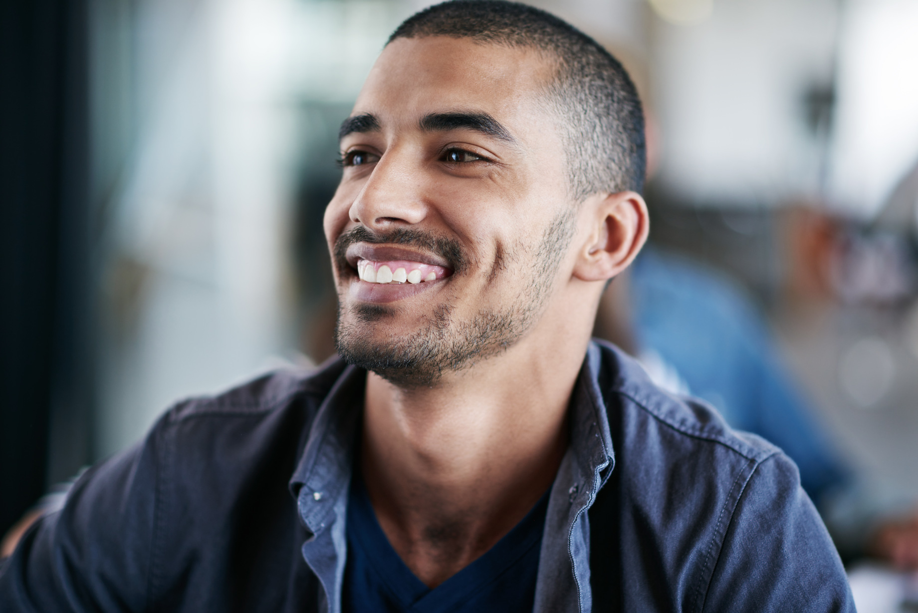 Hombre joven sonriente en un entorno natural, imagen para clínica de fisioterapia en Málaga.